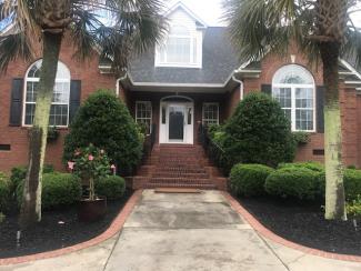 Black Rubber Mulch Landscaping Around Brick House
