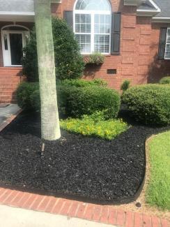 Black Rubber Mulch Landscaping Around Brick House